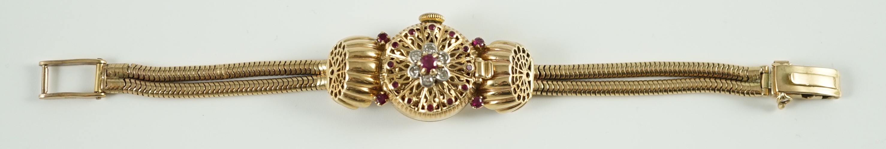 A lady's 1950's 9ct gold, ruby and diamond set manual wind cocktail watch, on a 9ct gold twin strand snake link bracelet